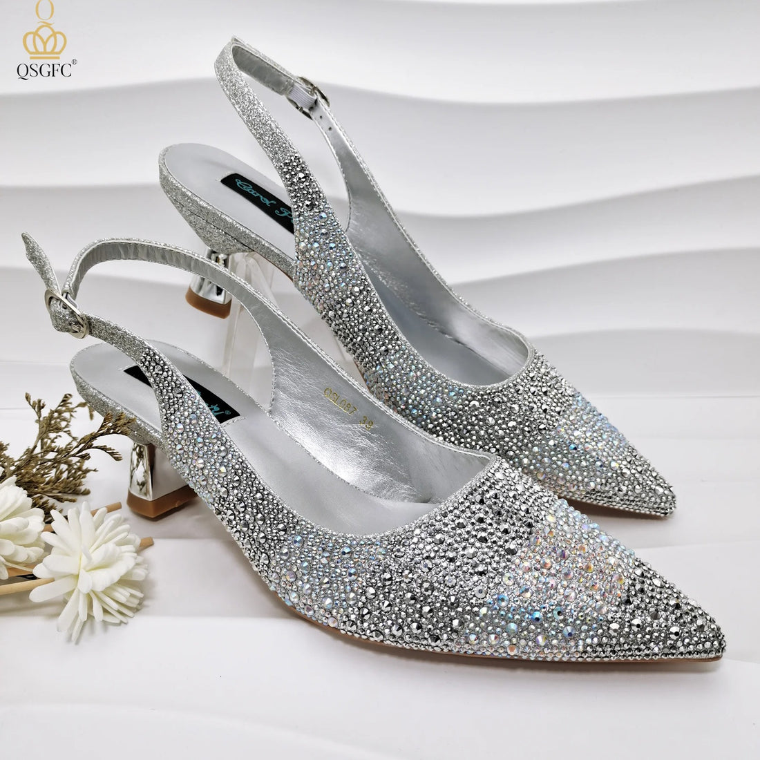 Silver shoes with very high heels and a decorative strap